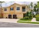 Well-kept townhome featuring a multi-car garage, second-floor balcony, and vibrant, professionally maintained tropical landscaping at 8098 Moonstone Dr # 17-203, Sarasota, FL 34233