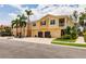 Townhome exterior showcasing multi-car garages, second-floor balconies, lush tropical landscaping and well-maintained grounds at 8098 Moonstone Dr # 17-203, Sarasota, FL 34233