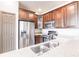 Close up of kitchen sink with stainless appliances and wood cabinets at 8098 Moonstone Dr # 17-203, Sarasota, FL 34233