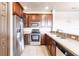 Kitchen features stainless appliances, wood cabinetry, and tile backsplash at 8098 Moonstone Dr # 17-203, Sarasota, FL 34233