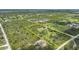 Aerial shot showcasing the property surrounded by dense trees and a pond with various homes nearby at 8312 Acorn Blvd, Punta Gorda, FL 33982