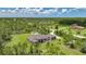 Expansive aerial view of a single-story home featuring lush landscaping and a metal roof at 8312 Acorn Blvd, Punta Gorda, FL 33982