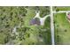 Expansive property featuring a home with a brown roof, surrounded by lush greenery and a winding driveway at 8312 Acorn Blvd, Punta Gorda, FL 33982