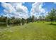 Expansive green backyard featuring a serene pond and comfortable seating area, perfect for outdoor enjoyment at 8312 Acorn Blvd, Punta Gorda, FL 33982