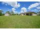 Expansive backyard featuring a well-maintained lawn, shed, and a beautifully designed home with a metal roof at 8312 Acorn Blvd, Punta Gorda, FL 33982