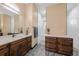 Bathroom featuring double vanities, wooden cabinets, and a seamless walk-in shower at 8312 Acorn Blvd, Punta Gorda, FL 33982