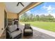 Relaxing covered patio with comfortable seating, an outdoor kitchen, and a serene view of the expansive backyard at 8312 Acorn Blvd, Punta Gorda, FL 33982