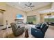 Spacious living room featuring stone fireplace, comfortable seating, and sliding doors to the outdoor living area at 8312 Acorn Blvd, Punta Gorda, FL 33982