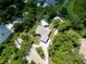 An aerial view of the property highlighting the home, pool house, detached garage and mature trees at 875 Bayshore Dr, Englewood, FL 34223