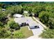 Aerial view showcases the property's lush landscaping and surrounding wooded area at 875 Bayshore Dr, Englewood, FL 34223