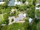 An aerial view of the property showcasing the home, detached garage, pool house, and expansive yard at 875 Bayshore Dr, Englewood, FL 34223