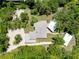Aerial view of a secluded home surrounded by lush greenery, pool house and detached garage at 875 Bayshore Dr, Englewood, FL 34223
