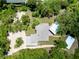 An aerial view showcasing the home, detached garage, and pool house nestled amongst lush trees at 875 Bayshore Dr, Englewood, FL 34223