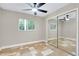 Bedroom with modern ceiling fan, window views, and sliding mirror closet doors at 875 Bayshore Dr, Englewood, FL 34223