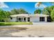 Well-maintained single-story home with mature trees and a two-car garage at 875 Bayshore Dr, Englewood, FL 34223