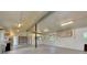 Spacious garage interior with roll-up door, concrete floors, ample lighting, and shelving at 875 Bayshore Dr, Englewood, FL 34223