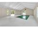 Bright indoor pool area with a minimalist design, white walls, and multiple windows offering natural light at 875 Bayshore Dr, Englewood, FL 34223