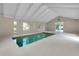 Bright indoor pool area with a minimalist design and windows that look out to the green landscaping at 875 Bayshore Dr, Englewood, FL 34223