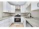 This kitchen boasts white cabinets, granite countertops, and stainless steel appliances at 875 Bayshore Dr, Englewood, FL 34223