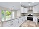Modern kitchen features white cabinets, granite countertops, and stainless steel appliances at 875 Bayshore Dr, Englewood, FL 34223
