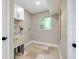 Laundry room with utility sink, overhead cabinets, and natural light at 875 Bayshore Dr, Englewood, FL 34223