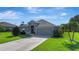 Well-maintained single-story home featuring lush lawn, mature landscaping, and a two-car garage at 96 Mocha Ct, Punta Gorda, FL 33983