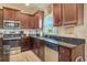 Bright kitchen features stainless steel appliances, dark wood cabinets, granite countertops and sink with window at 96 Mocha Ct, Punta Gorda, FL 33983