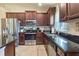 Spacious kitchen with stainless steel appliances, dark wood cabinets and granite countertops and a window over the sink at 96 Mocha Ct, Punta Gorda, FL 33983