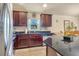 Open concept kitchen features dark wood cabinets and granite countertops, with a view to the dining area at 96 Mocha Ct, Punta Gorda, FL 33983