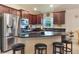 Well-equipped kitchen features dark wood cabinets, granite countertops, stainless steel appliances, and a large island with bar stool seating at 96 Mocha Ct, Punta Gorda, FL 33983