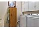 Functional laundry room with white cabinetry, wooden cabinet and washer and dryer units at 96 Mocha Ct, Punta Gorda, FL 33983