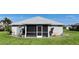 Exterior shot featuring a screened in patio, storm shutters, and landscaped garden beds for enhanced curb appeal at 96 Mocha Ct, Punta Gorda, FL 33983