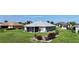A serene property featuring a screened-in patio area, surrounded by lush greenery and a well-maintained lawn at 96 Mocha Ct, Punta Gorda, FL 33983