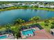 Aerial view of house with pool, screened in lanai, and a lake view at 10131 Winding River Rd, Punta Gorda, FL 33950