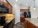 Kitchen featuring stone countertops, stainless steel appliances, and dark brown cabinets at 10131 Winding River Rd, Punta Gorda, FL 33950