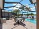 Covered patio with ample seating space for entertaining with views of the lake and pool at 10131 Winding River Rd, Punta Gorda, FL 33950
