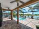 A relaxing screened-in patio features a swimming pool overlooking a scenic lake view at 10131 Winding River Rd, Punta Gorda, FL 33950