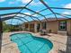 Inviting screened-in pool area with a sparkling pool, brick patio, and comfortable outdoor seating at 10131 Winding River Rd, Punta Gorda, FL 33950