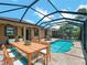 Inviting screened-in pool area with outdoor dining space and serene landscaping for relaxation and entertainment at 10131 Winding River Rd, Punta Gorda, FL 33950