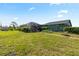Large backyard with a screened-in pool area and lush landscaping on a sunny day at 11068 Jacqueline Ave, Englewood, FL 34224