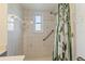 Tiled bathroom with safety bar, shower head and nature-themed shower curtain, accented by a bright window at 11068 Jacqueline Ave, Englewood, FL 34224