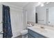 Standard bathroom includes blue vanity, toilet, and tub with patterned shower curtain at 11068 Jacqueline Ave, Englewood, FL 34224