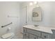 Clean bathroom featuring neutral colors, a vanity with mirror and grab bar for accessibility at 11068 Jacqueline Ave, Englewood, FL 34224