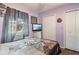 A bedroom with purple walls, a view of the outside and light coming in from the window at 11068 Jacqueline Ave, Englewood, FL 34224