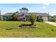 Quaint home featuring a well-kept lawn, mature landscaping, and an American flag at 11068 Jacqueline Ave, Englewood, FL 34224