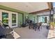 Covered patio area with seating, shelving, and grill, leads to an inviting pool area at 11068 Jacqueline Ave, Englewood, FL 34224