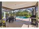 Screened-in patio area with outdoor dining set and barbecue grill near a pool at 11068 Jacqueline Ave, Englewood, FL 34224