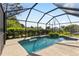 Inviting in-ground pool area enclosed with screen, surrounded by lush landscaping for privacy at 11068 Jacqueline Ave, Englewood, FL 34224
