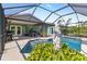View of backyard pool area featuring a patio, lovely greenery and statue within screened enclosure at 11068 Jacqueline Ave, Englewood, FL 34224