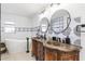 Bright bathroom featuring dual vanity, round mirrors, decorative tile accent, and freestanding tub at 123 Annapolis Ln, Rotonda West, FL 33947